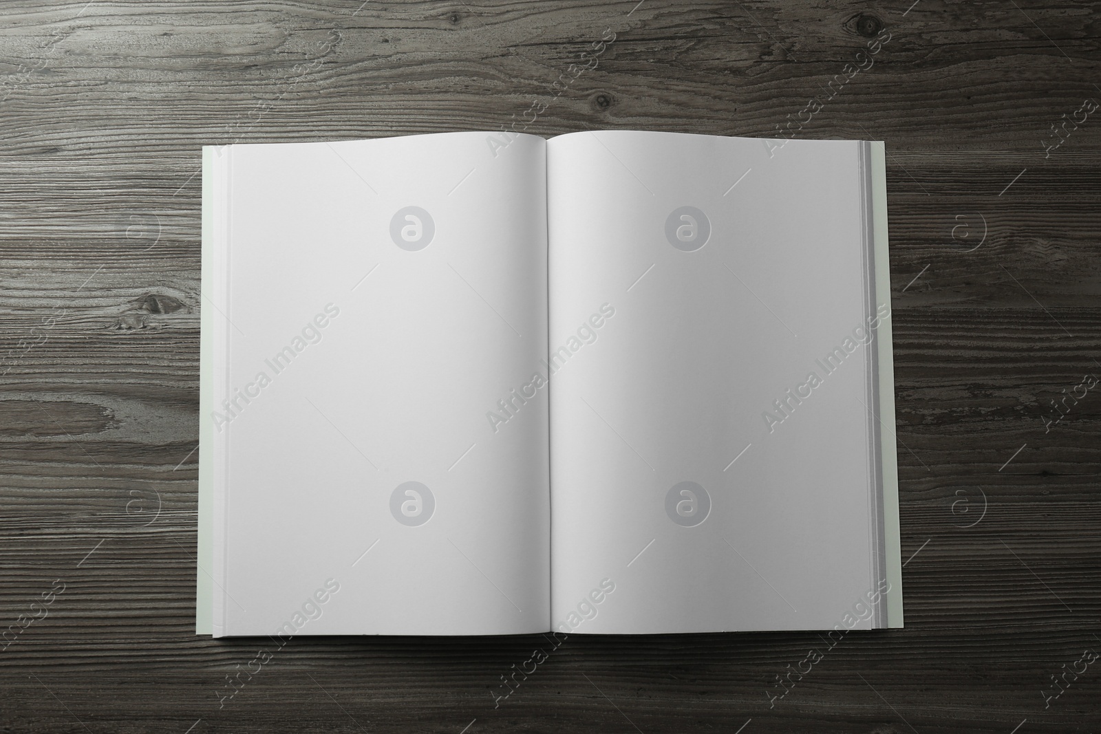 Photo of Open blank paper brochure on wooden table, top view. Mockup for design