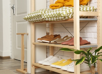 Cozy hallway interior with wooden shelving unit. Stylish design idea