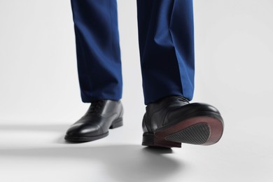 Photo of Businessman in leather shoes on white background, closeup