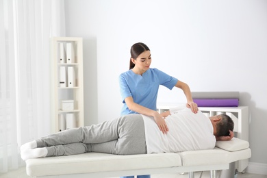 Photo of Doctor working with patient in hospital. Rehabilitation massage