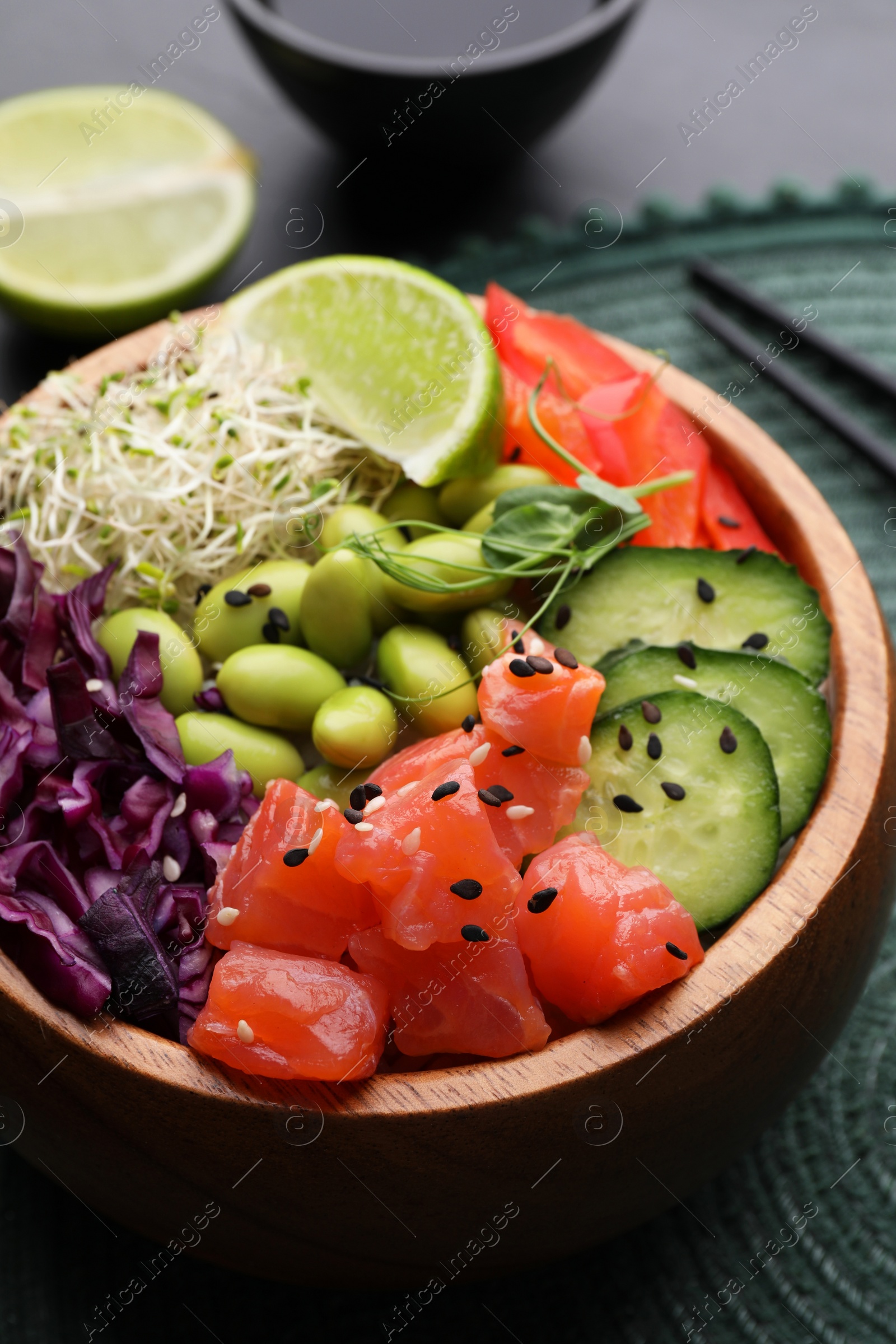 Photo of Delicious poke bowl with vegetables, fish and edamame beans on table, closeup