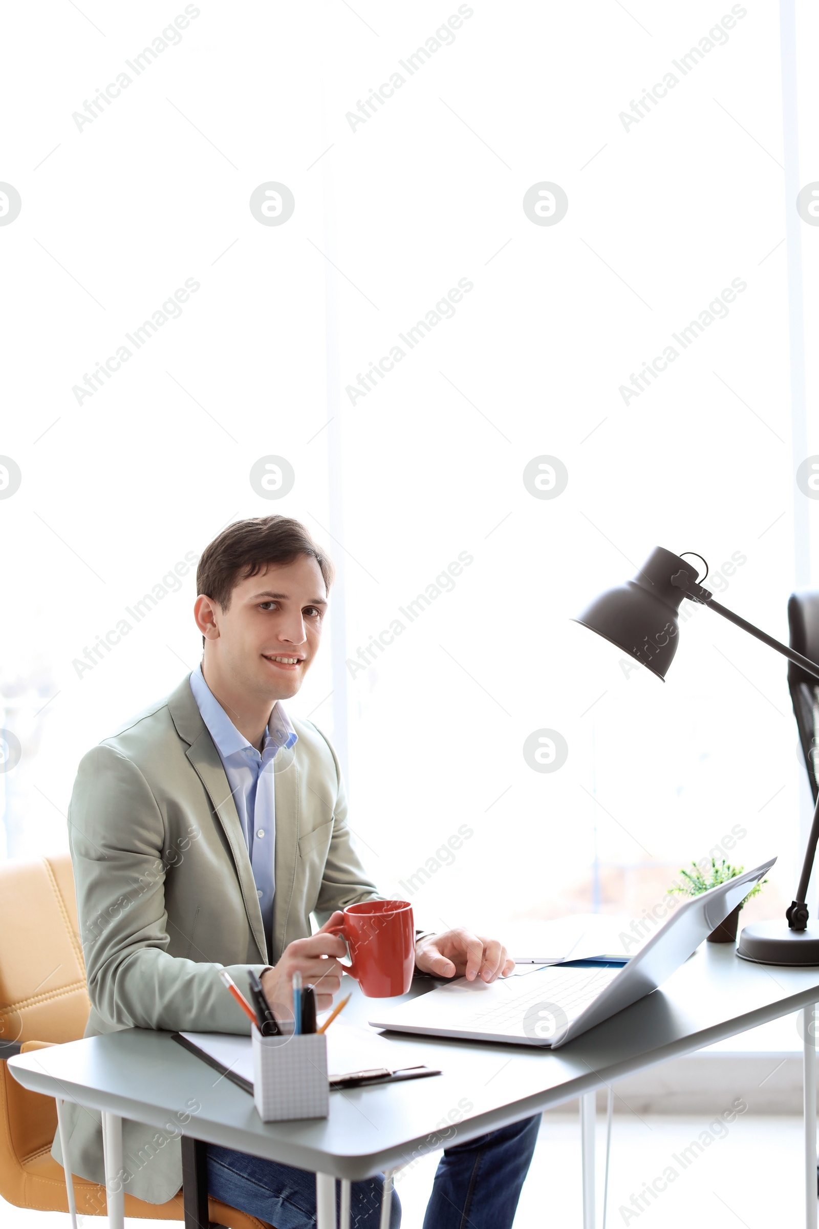 Photo of Portrait of confident young businessman drinking coffee at table