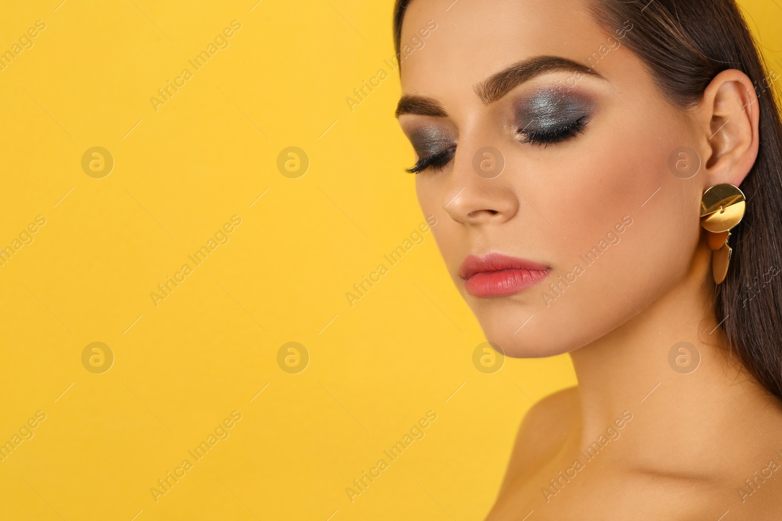 Photo of Portrait of beautiful woman with stylish makeup on color background. Space for text