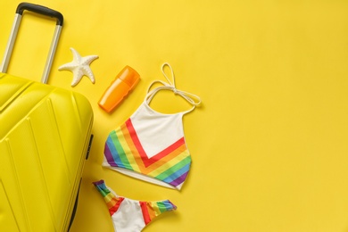 Photo of Flat lay composition with suitcase and  bikini on color background. Space for text