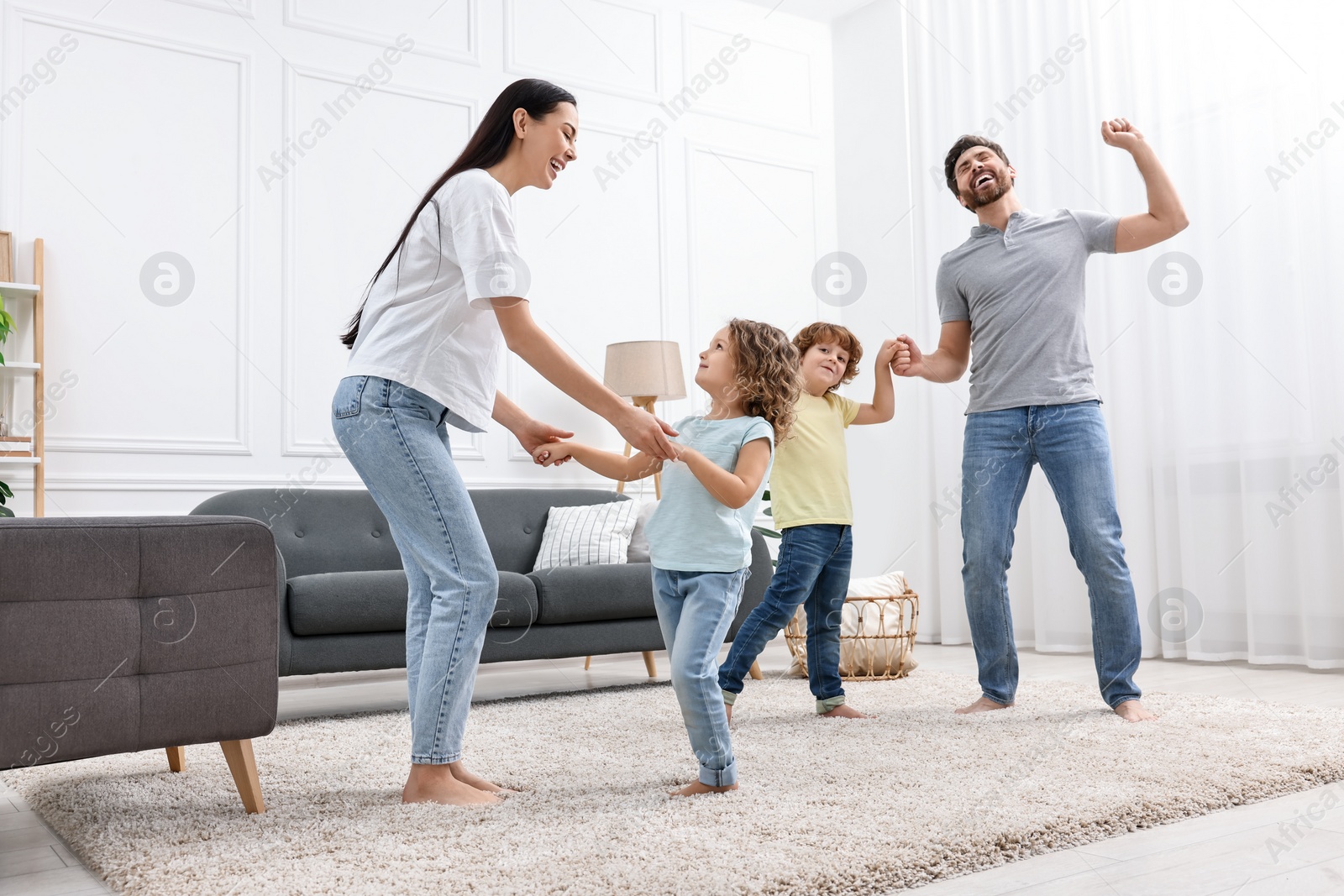 Photo of Happy family dancing in living room, low angle view