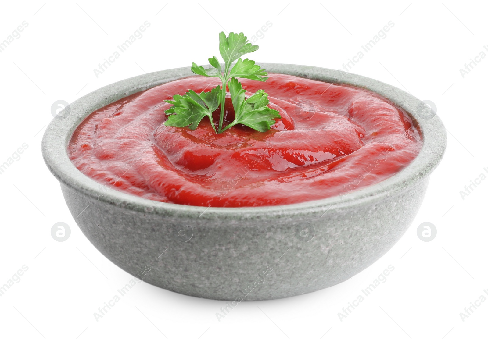 Photo of Tasty ketchup with parsley in bowl isolated on white. Tomato sauce
