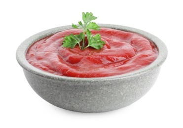 Tasty ketchup with parsley in bowl isolated on white. Tomato sauce