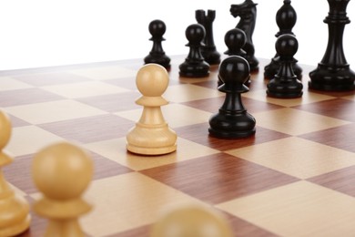 Photo of Chess pieces on wooden board against white background