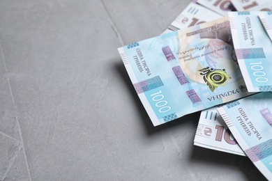 Photo of Ukrainian money on grey background, closeup. Space for text