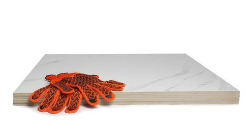 Photo of Stack of ceramic tiles and gloves on white background