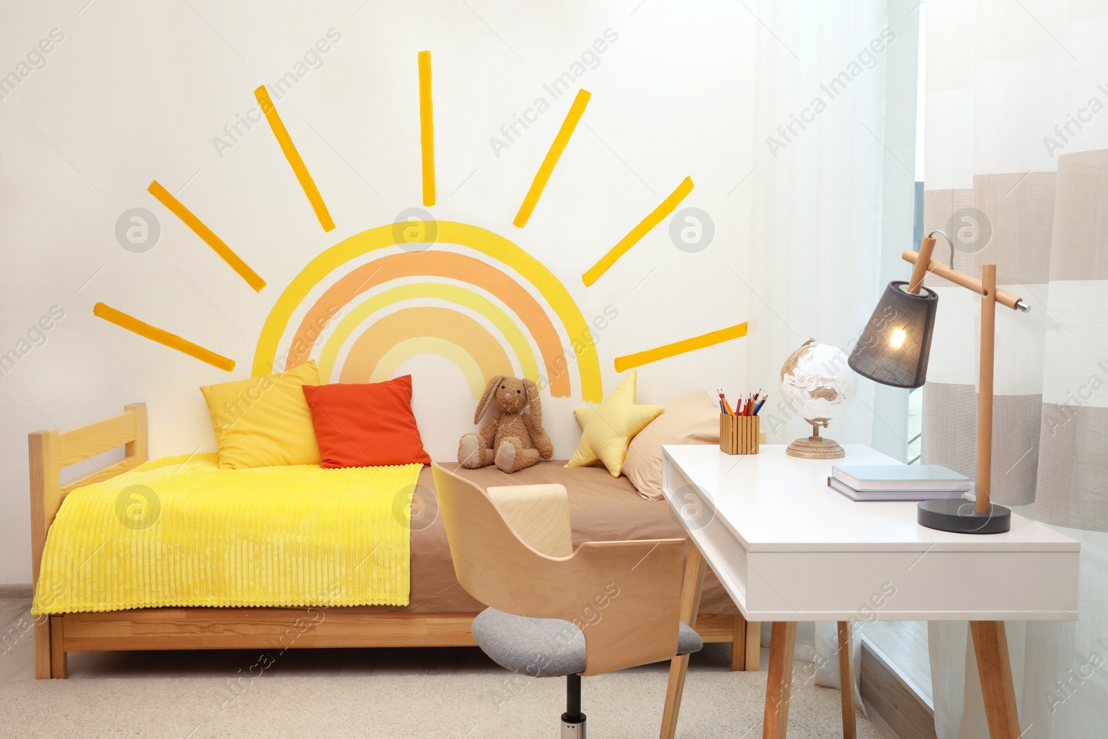 Photo of Cute child's room interior with beautiful sun painted on wall