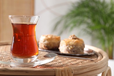 Photo of Traditional Turkish tea in glass on wicker table. Space for text