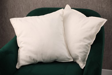 Soft pillows on green armchair in room