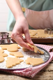 Photo of Woman making Christmas cookies at wooden table, closeup