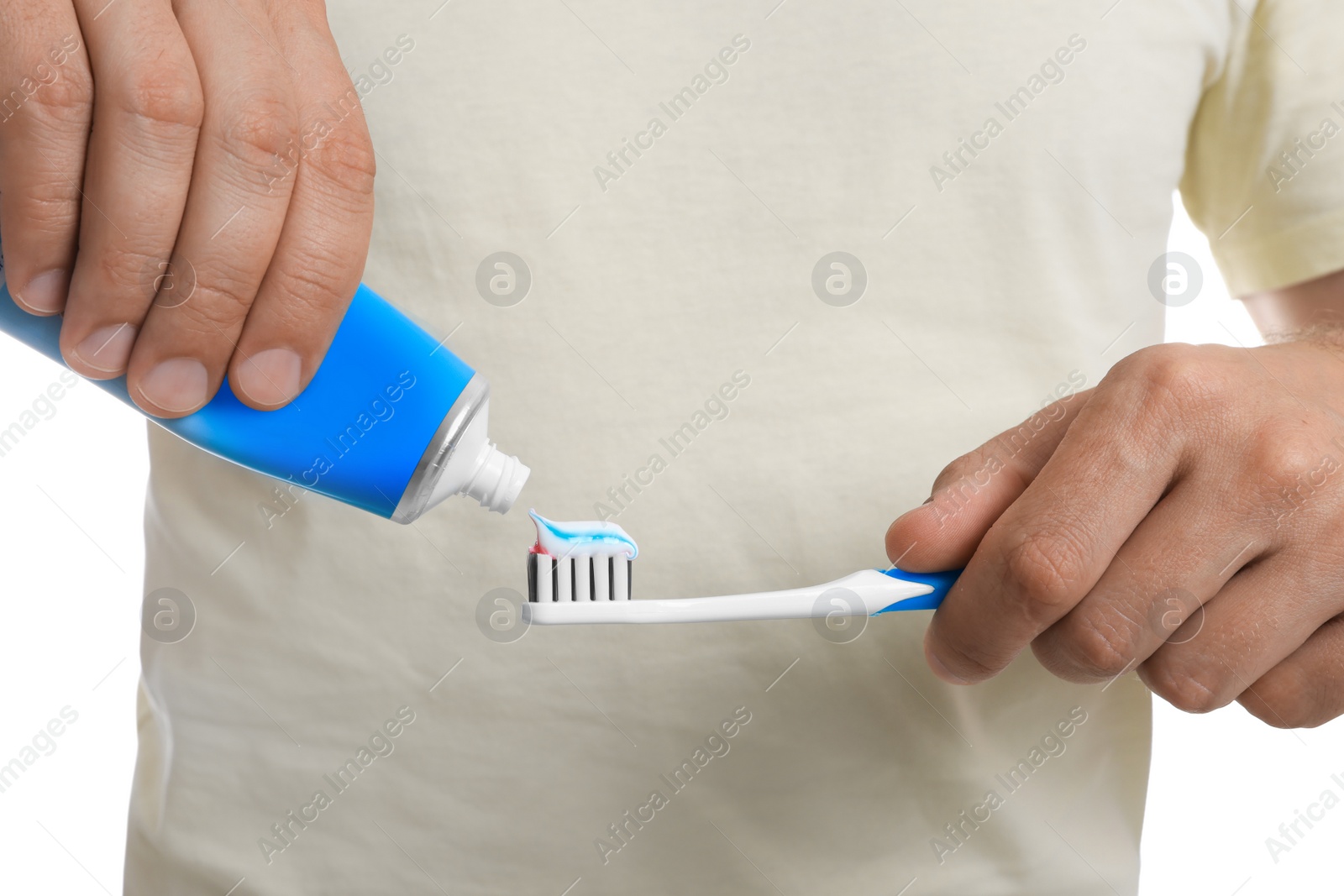 Photo of Man applying toothpaste on brush against white background, closeup