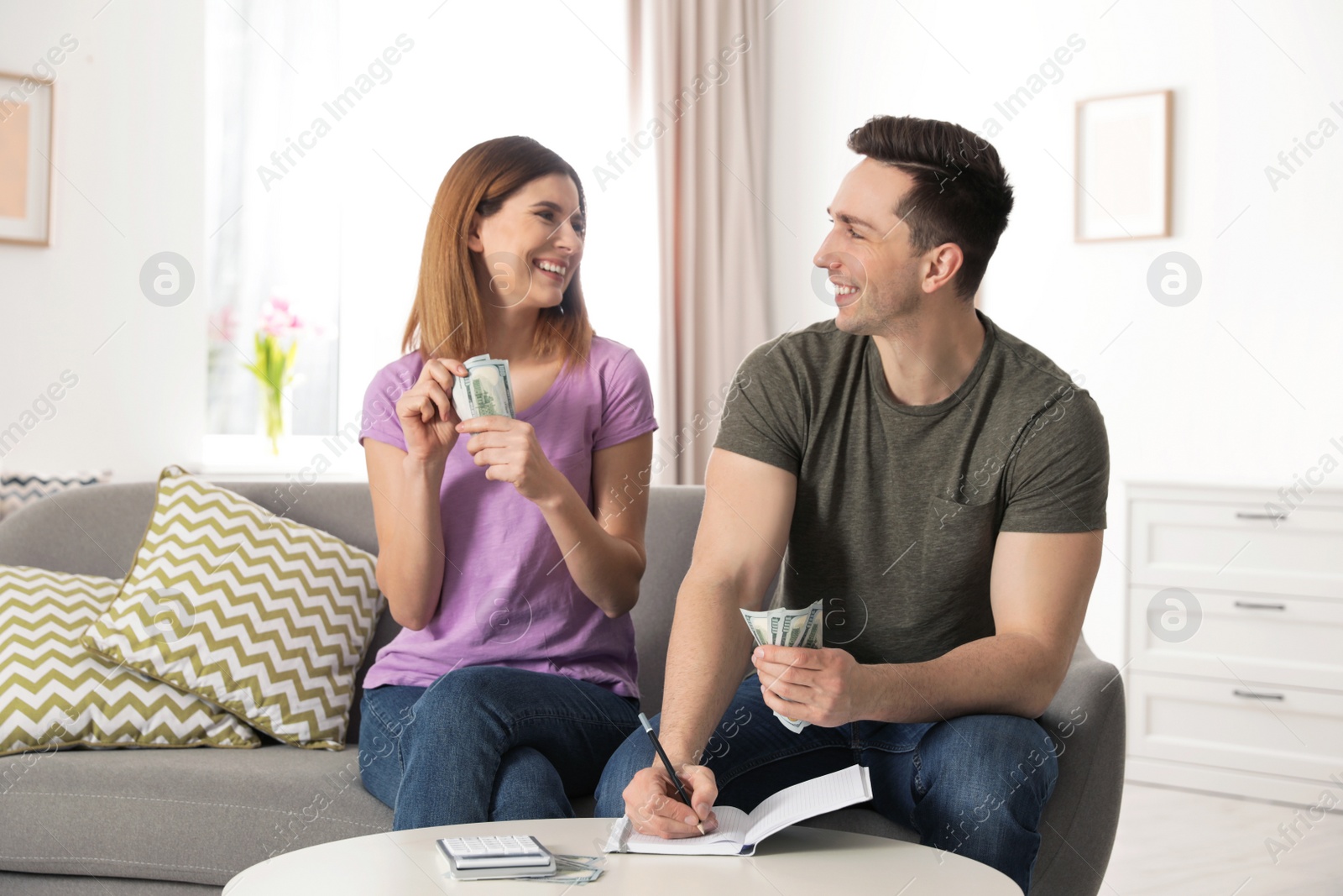 Photo of Couple managing budget to save money in living room