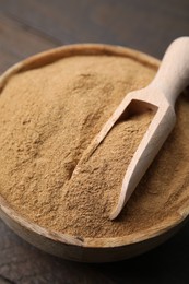 Photo of Dietary fiber. Psyllium husk powder in bowl and scoop on table, closeup