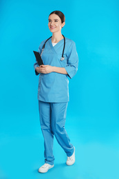 Photo of Doctor with clipboard walking on blue background
