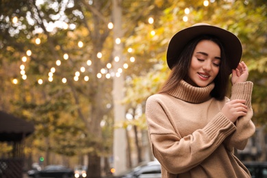 Photo of Young woman wearing stylish clothes on city street, space for text. Autumn look