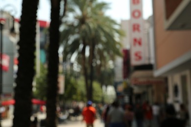 Photo of Blurred view of city street with modern buildings and palm trees