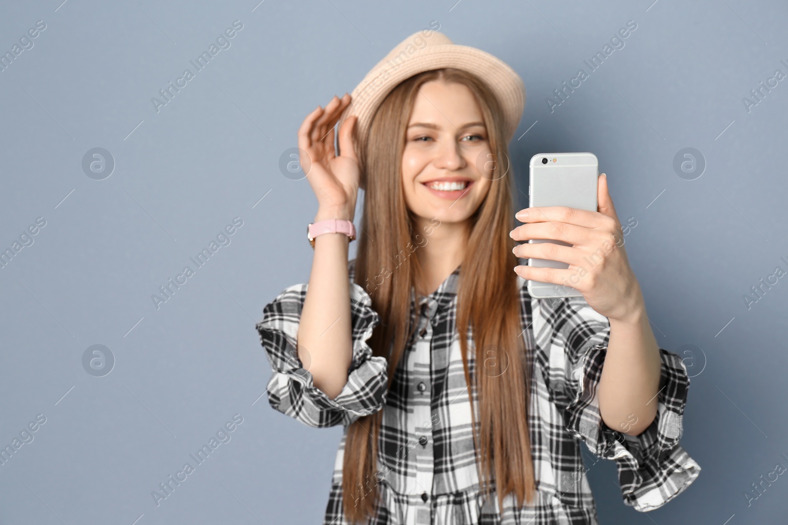 Photo of Young beautiful woman taking selfie against grey background