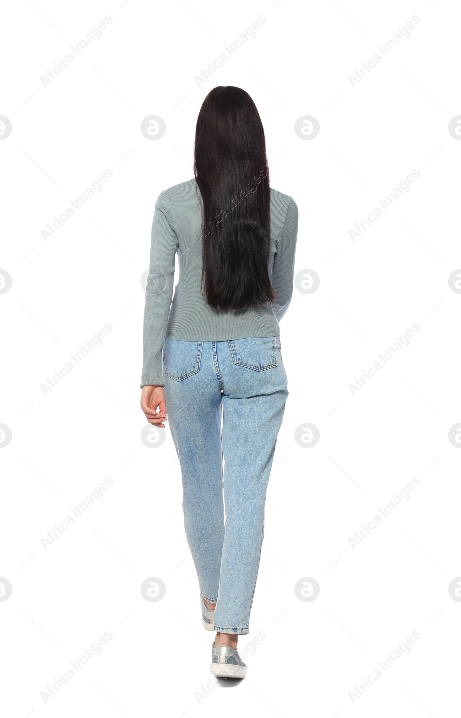Photo of Woman in casual outfit walking on white background, back view