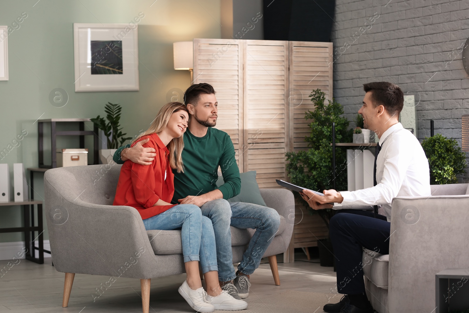 Photo of Young happy couple after therapy session with family psychologist indoors