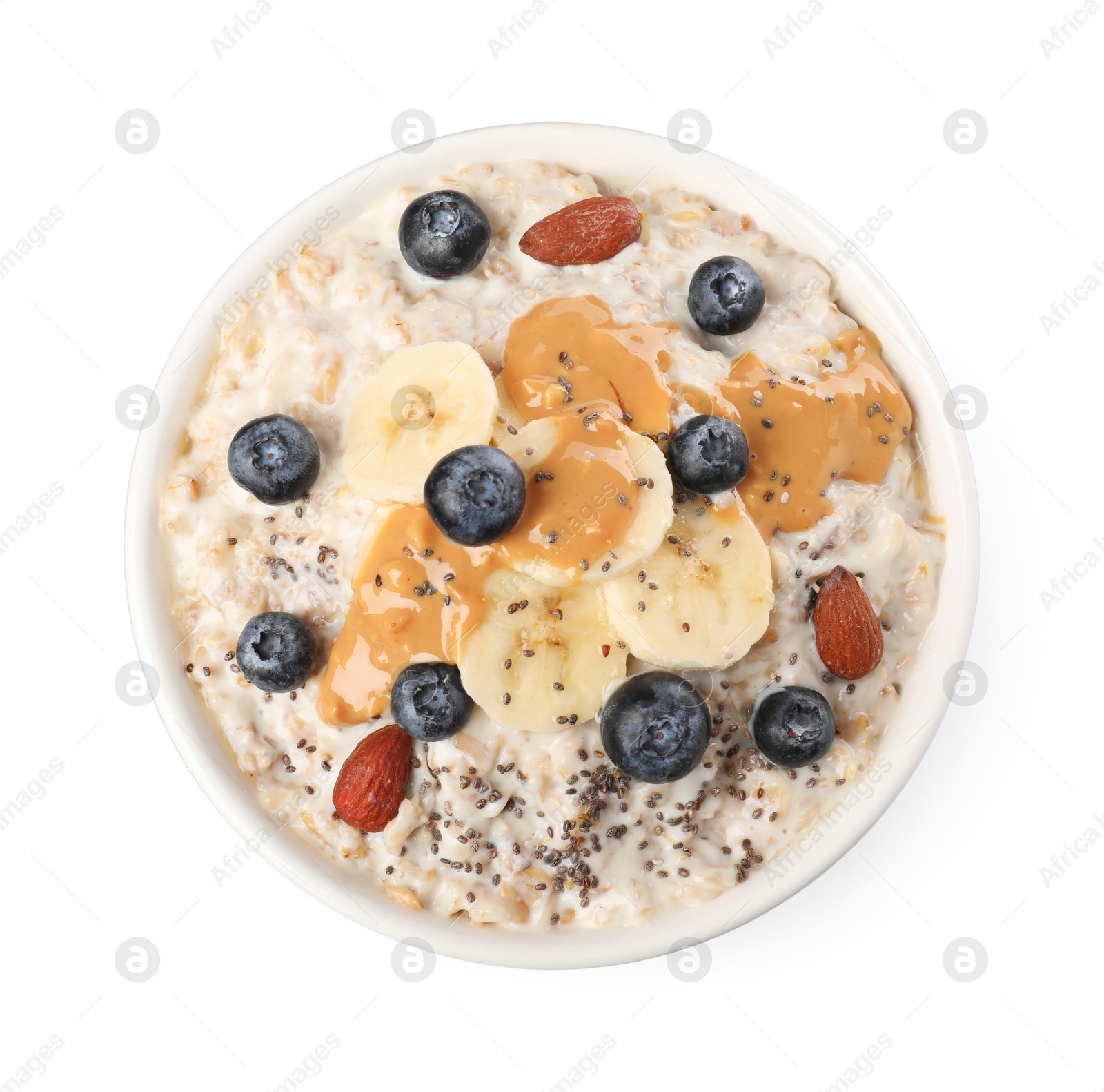 Photo of Tasty boiled oatmeal with blueberries, banana, chia seeds almonds and peanut butter in bowl isolated on white, top view