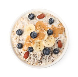 Photo of Tasty boiled oatmeal with blueberries, banana, chia seeds almonds and peanut butter in bowl isolated on white, top view
