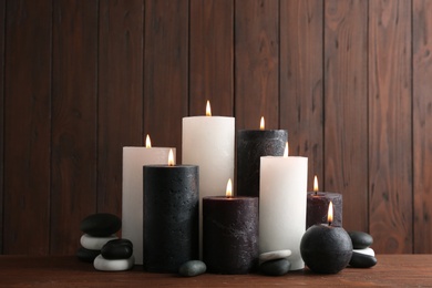 Composition with burning candles on table against wooden background