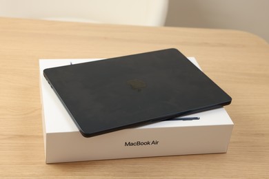 Leiden, Netherlands - October 6, 2023: Modern black MacBook Air and box on wooden table