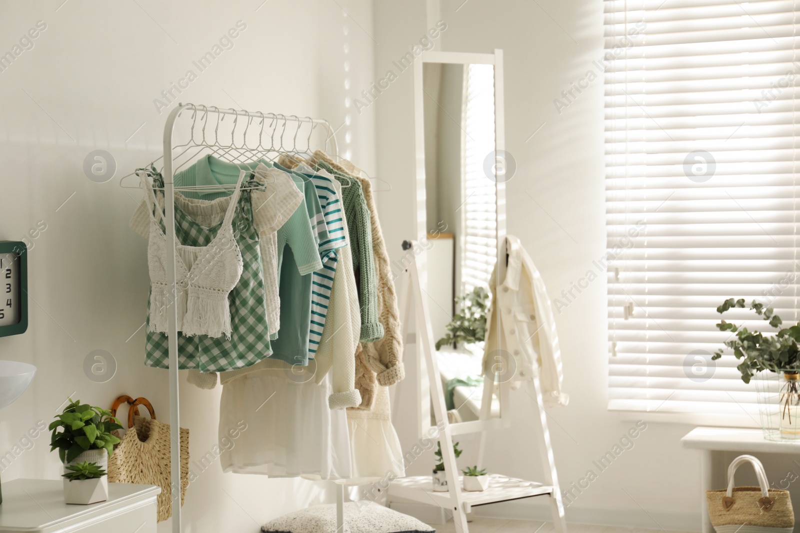 Photo of Dressing room interior with clothing rack and mirror