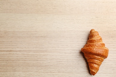 Photo of Fresh croissant on wooden background, top view with space for text. French pastry