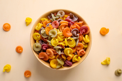 Photo of Colorful insalatonde pasta on beige background, flat lay