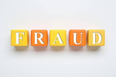 Word Fraud of wooden cubes with letters on white background, top view