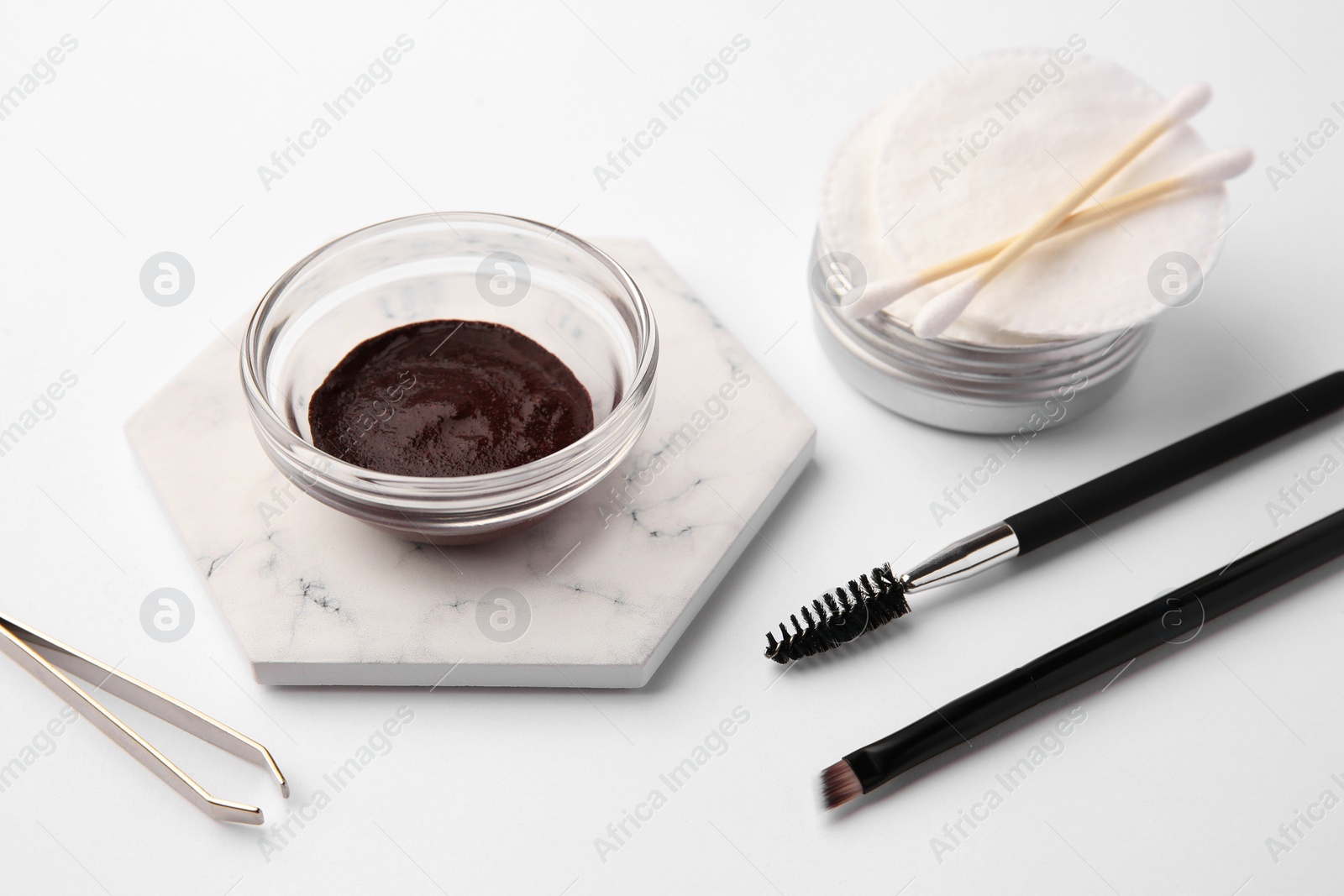 Photo of Eyebrow henna and professional tools on white background, closeup