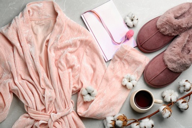 Photo of Flat lay composition with fluffy slippers and robe on grey background. Comfortable home outfit