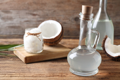 Photo of Coconut oil in glass jug on wooden table