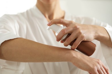 Photo of Woman applying self-tanning product onto arm, closeup
