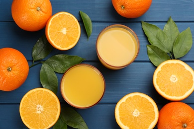 Photo of Delicious orange juice and fresh fruits on blue wooden table, flat lay