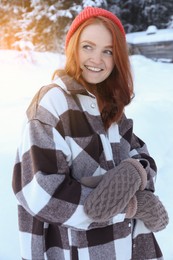 Portrait of beautiful young woman on snowy day outdoors. Winter vacation