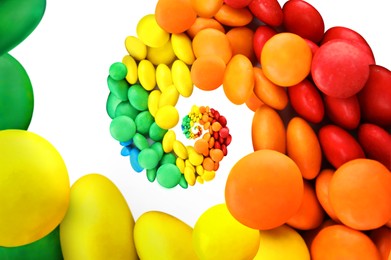 Image of Whirl of colorful candies on white background