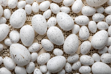 Photo of Many painted Easter eggs on knitted lace fabric, flat lay