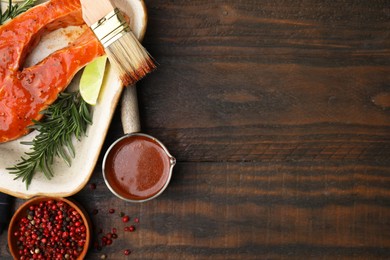 Photo of Fresh marinade, fish and other products on wooden table, flat lay. Space for text
