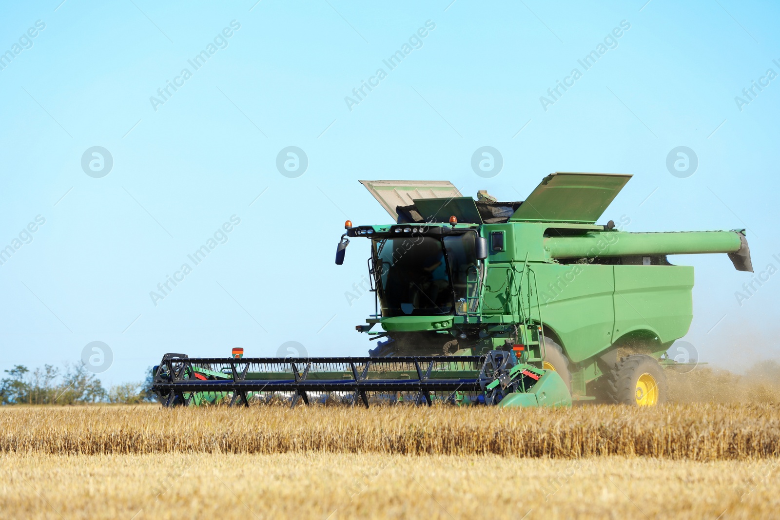 Photo of Modern combine harvester working in agricultural field