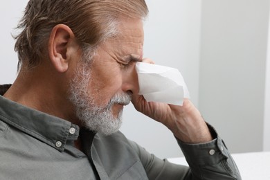 Photo of Upset senior man wiping tears with napkin at home, closeup. Loneliness concept