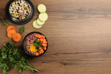 Photo of Pet food and natural ingredients on wooden table, flat lay. Space for text