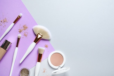 Flat lay composition with makeup brushes on color background. Space for text