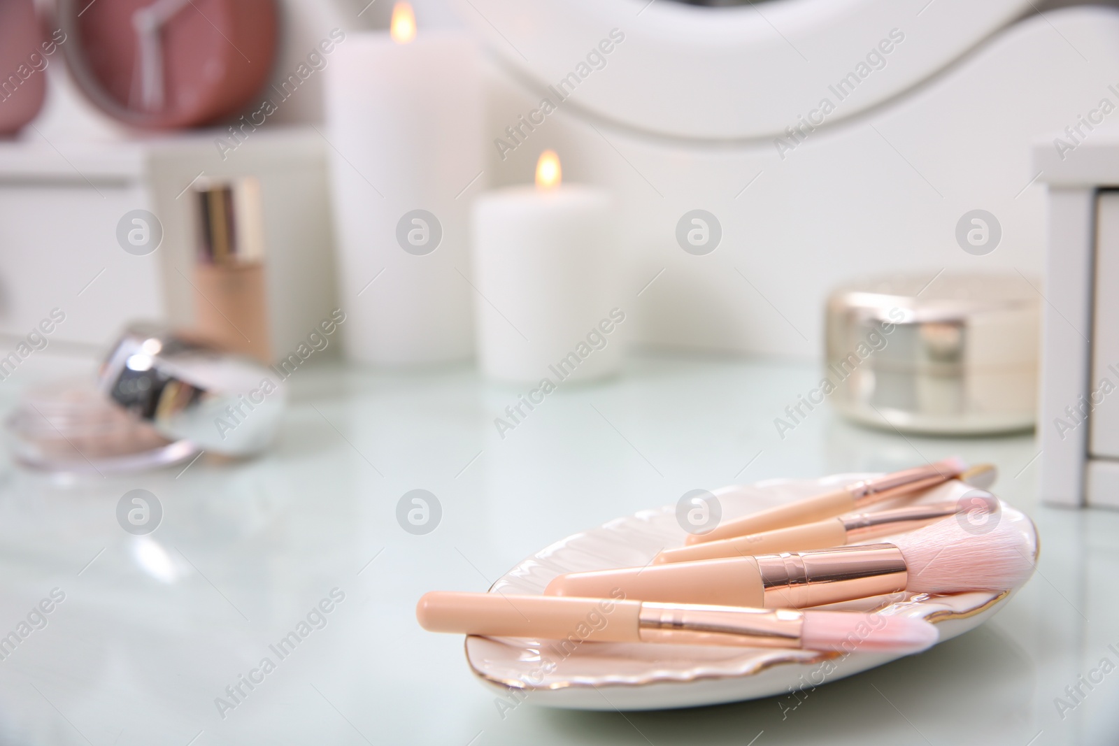 Photo of Set of makeup brushes on white dressing table