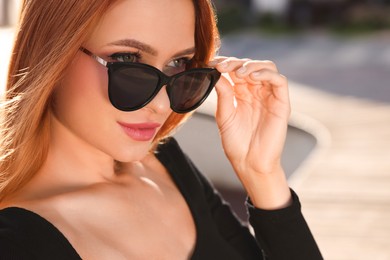 Photo of Beautiful woman in sunglasses outdoors, space for text